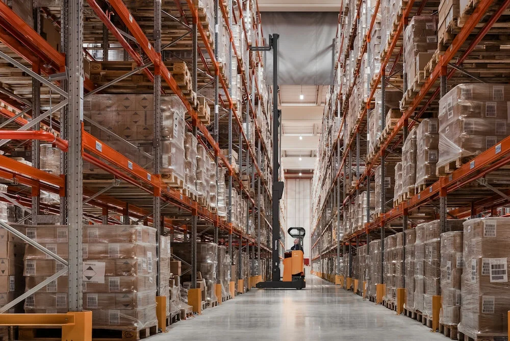 BT Reflex RRE160HE reach truck with tilting cabin. Application photo in warehouse environment.