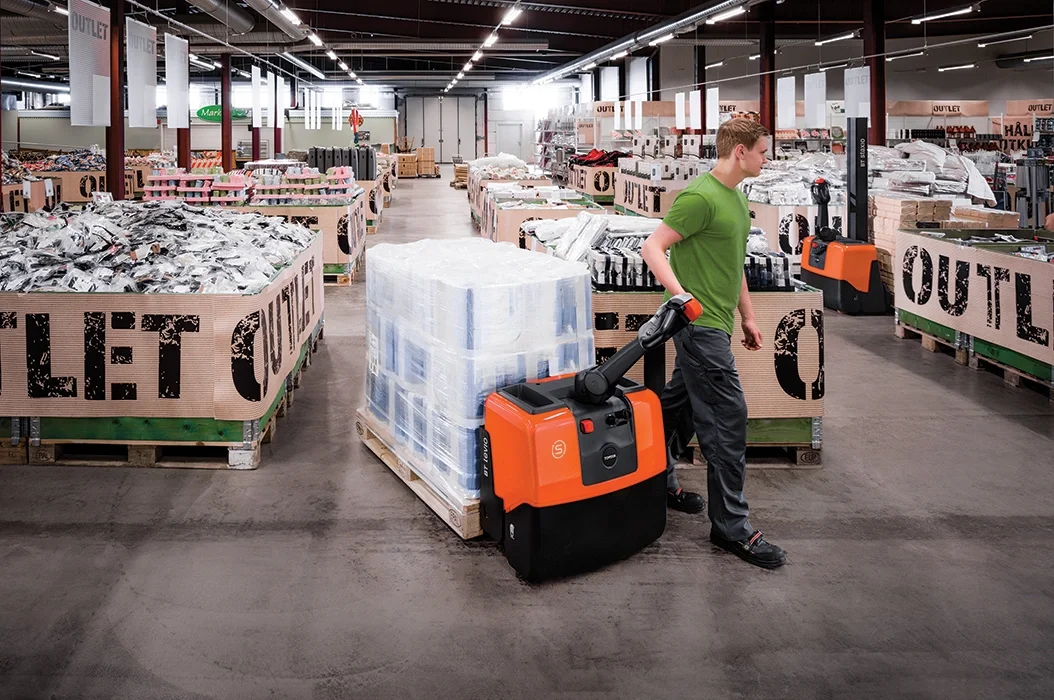 BT Levio LWE130 powered pallet truck, electric walkie low-lifter. Application photo in a warehouse environment.