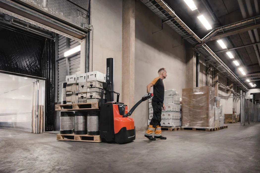 BT Staxio SWE080L electric walkie stacker with elevating support arms. Application photo of loading scenario.