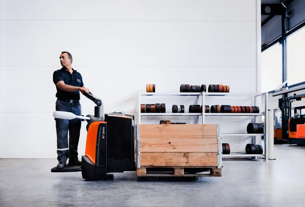 BT Levio powered pallet truck, electric low-lifter with platform. Application photo in a warehouse environment. 