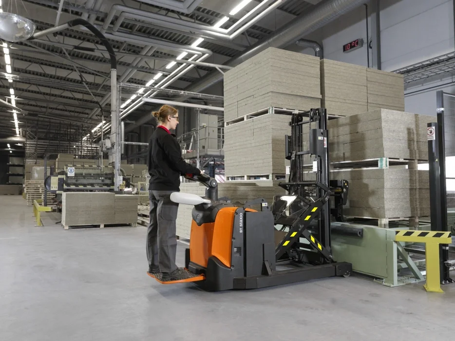 BT Staxio SPE120XR, electric stacker with reach mast, platform, and side guards. Application photo in a warehouse environment.