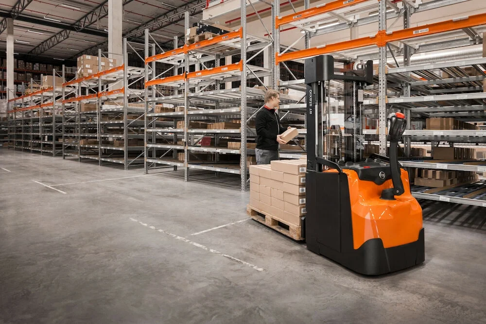 BT Staxio SWE145 electric walkie stacker. Application photo in warehouse environment.