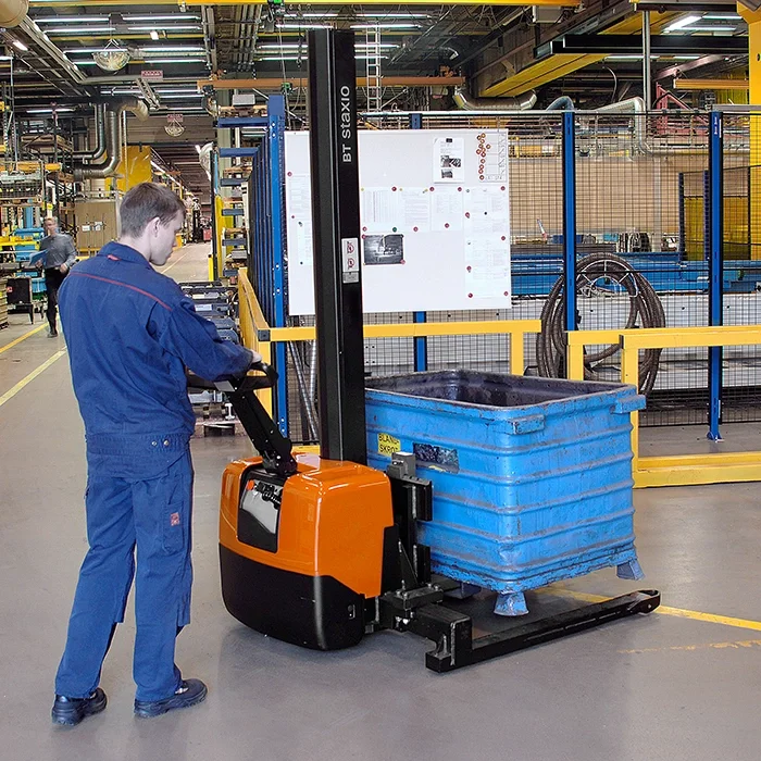 BT Staxio HWE100S powered stacker, electric walkie stacker truck with straddle. Application photo in a manufacturing environment. 