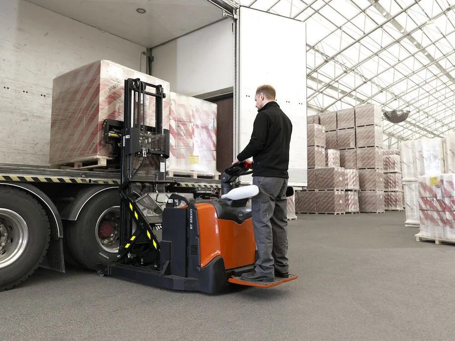 BT Staxio SPE120XR, electric stacker with reach mast, platform, and side guards. Application photo of lorry loading. 