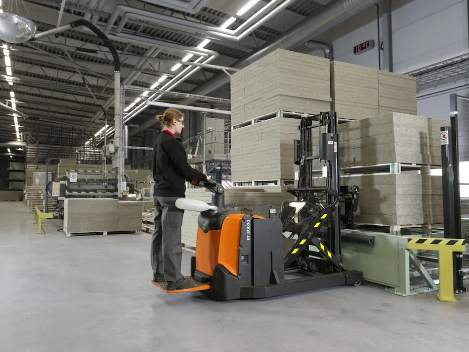 BT Staxio SPE120XR, electric stacker with reach mast, platform, and side guards. Application photo in a warehouse environment.